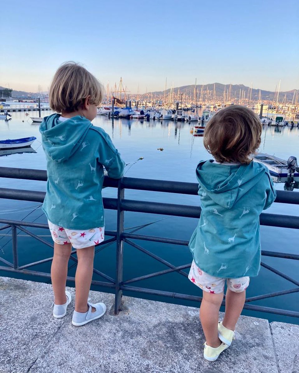 Dos peques mirando los barcos en el puerto de Baiona